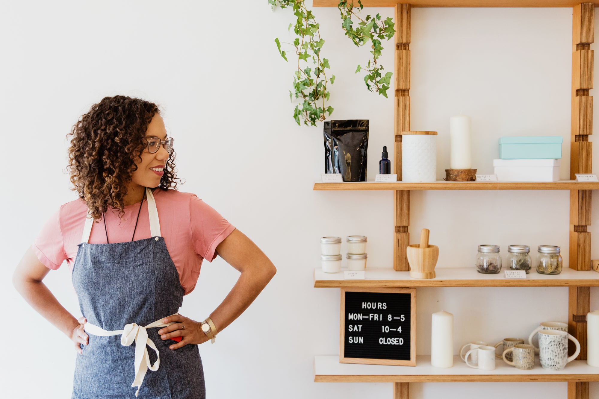 small business owner looking to the left at her shelves